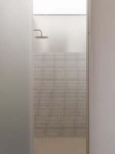 A shower head and grid wall is visible.