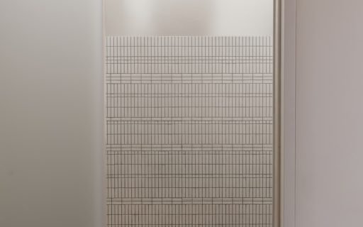 A shower head and grid wall is visible.